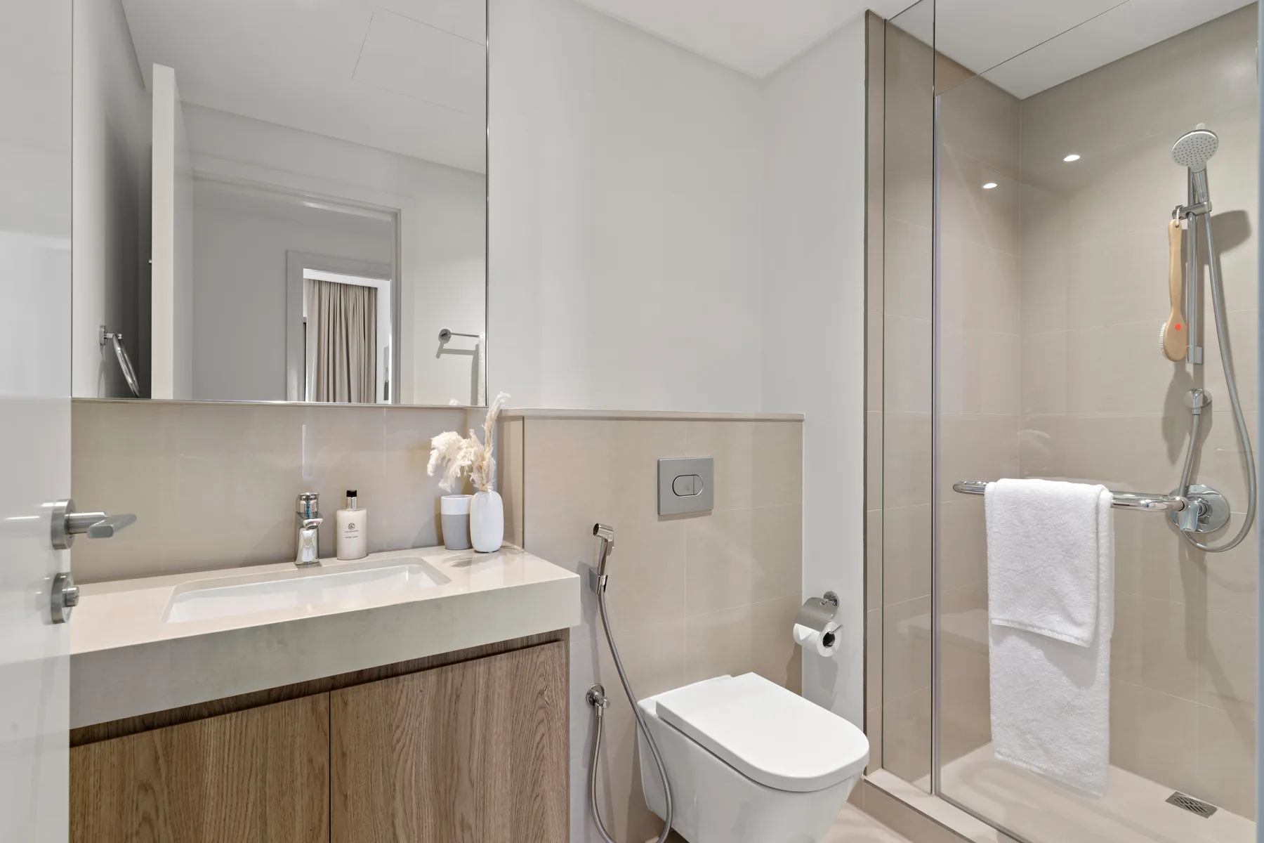 A modern bathroom with a vanity, toilet, and glass shower.