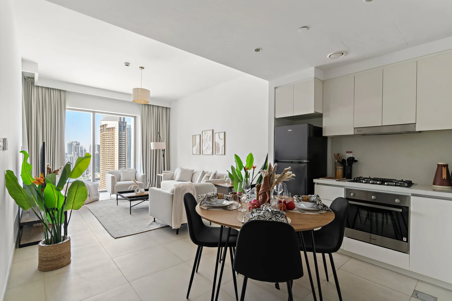 An open-plan living and dining area with a kitchen and large windows.