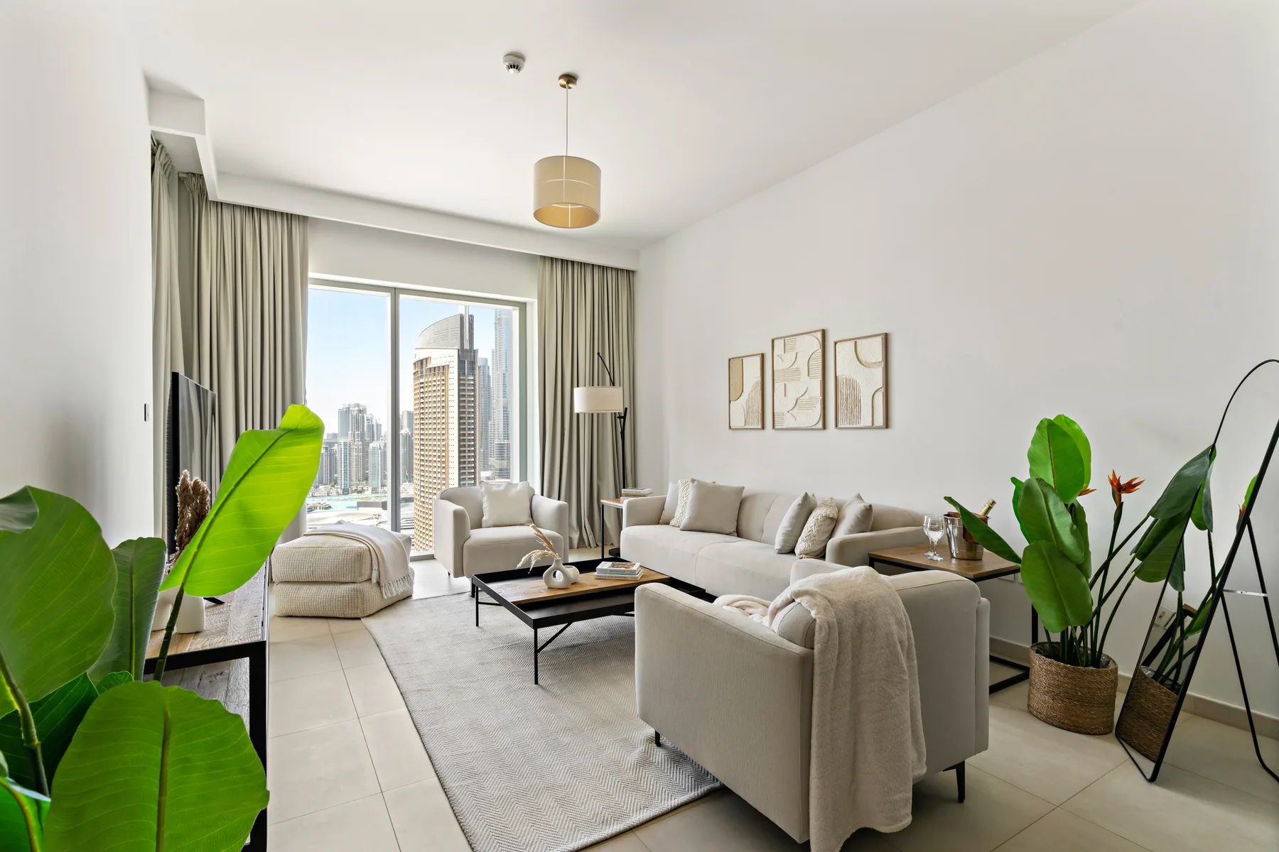 A bright living room with light seating, a coffee table, and large windows.