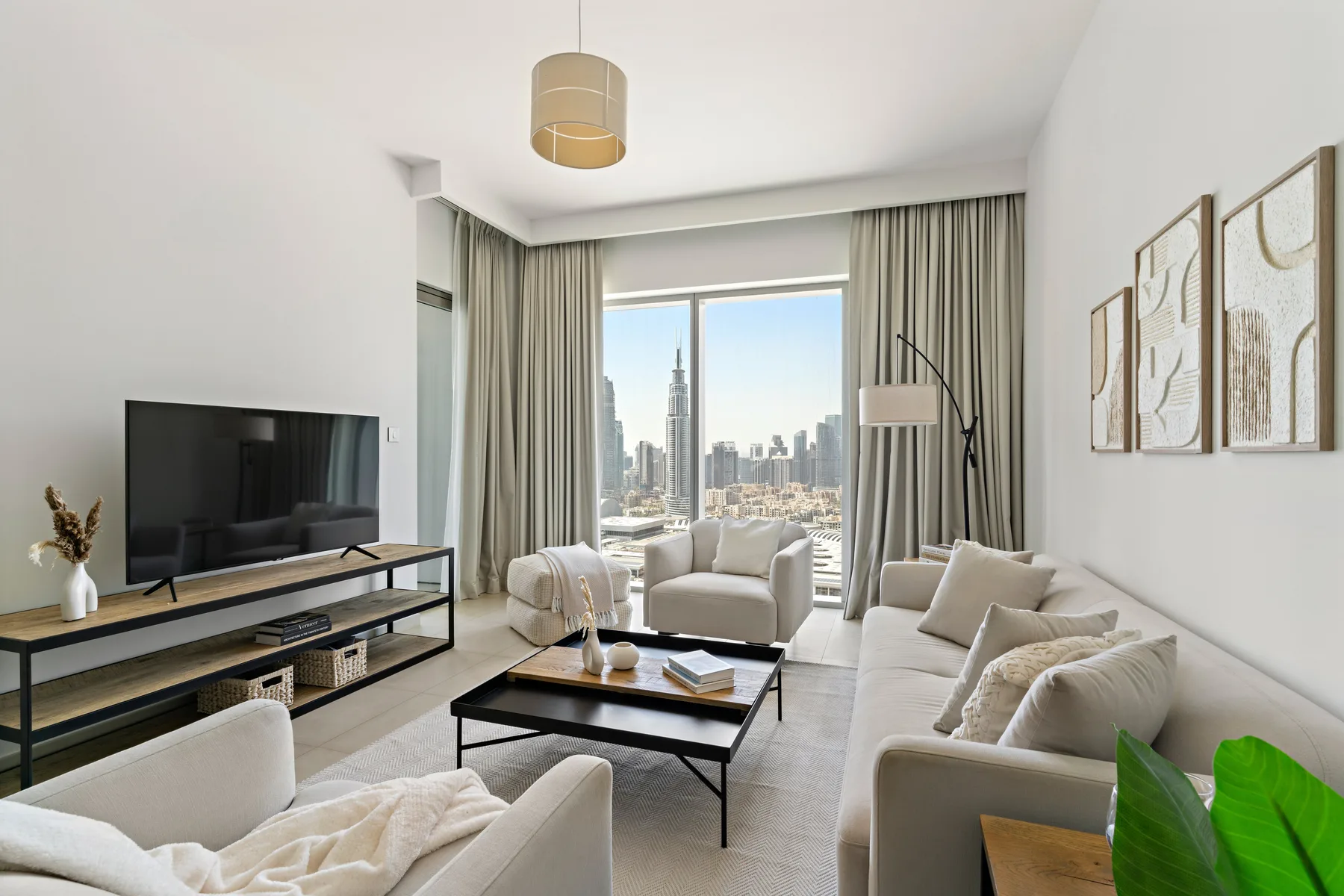 A bright living room with seating arranged around a coffee table and large windows.