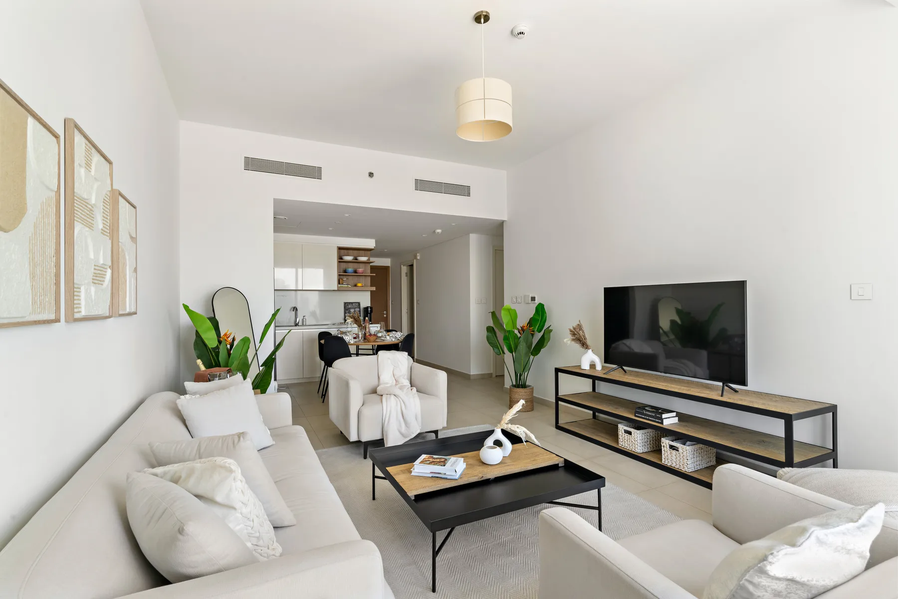 Una sala de estar luminosa con asientos, una mesa de centro y un televisor.