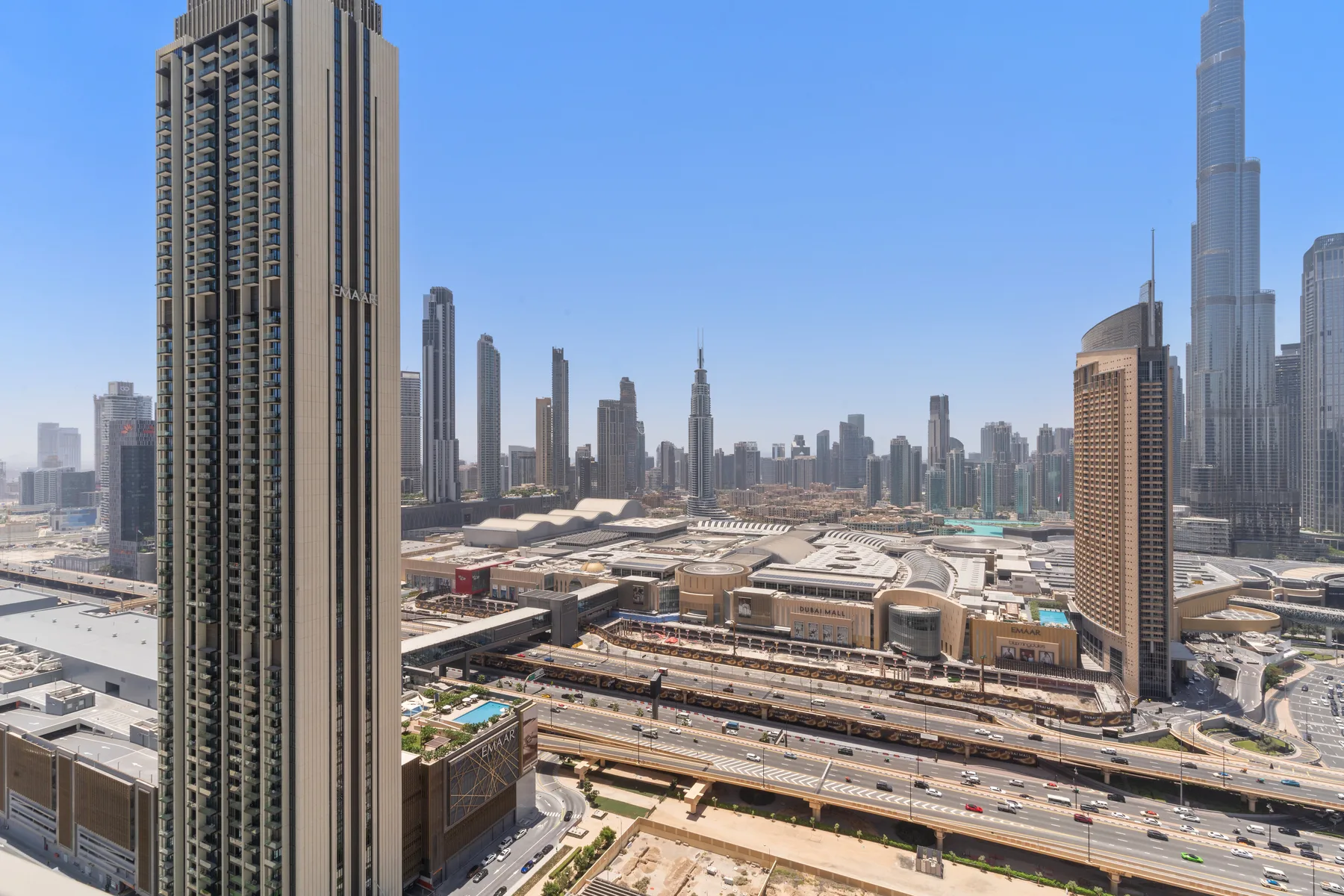 A city skyline viewed from above, with tall buildings and elevated roads.