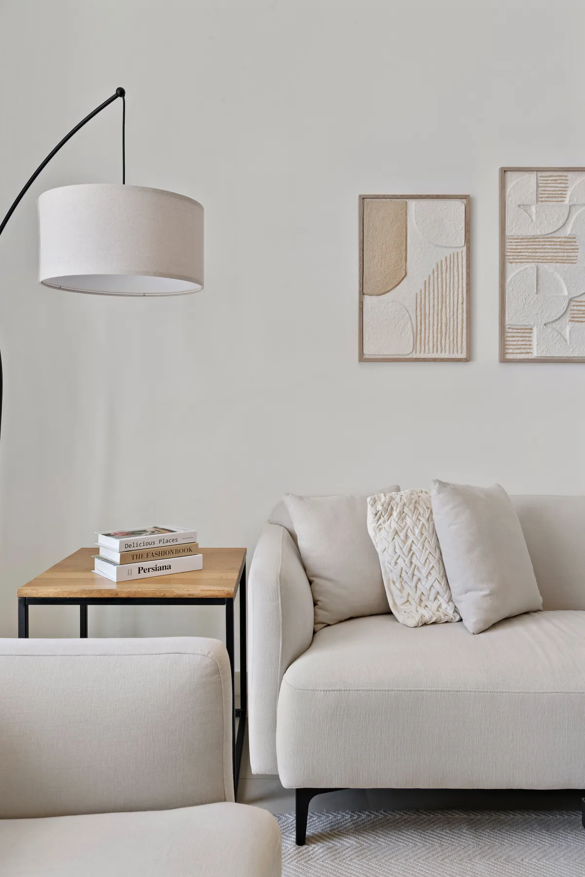 A light-colored living room seating area with framed abstract artwork on the wall.