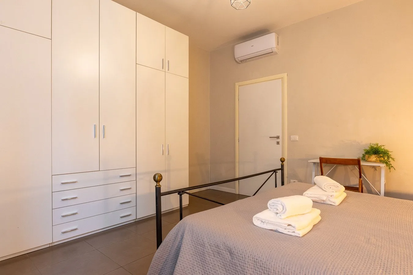Dormitorio con cama, armarios empotrados y aire acondicionado en la pared.