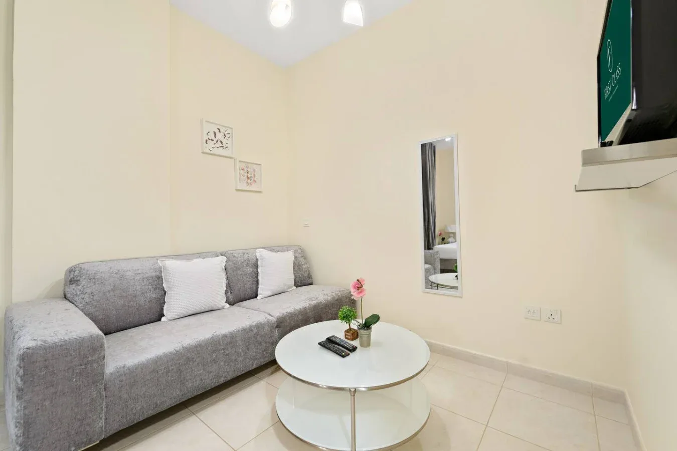 Una sala luminosa con asientos grises y una mesa de centro redonda.