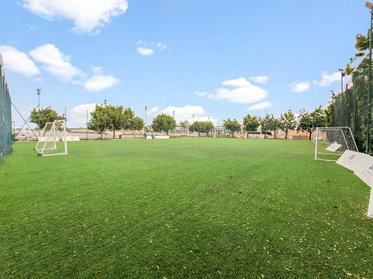 Una cancha deportiva al aire libre con césped verde y porterías pequeñas.