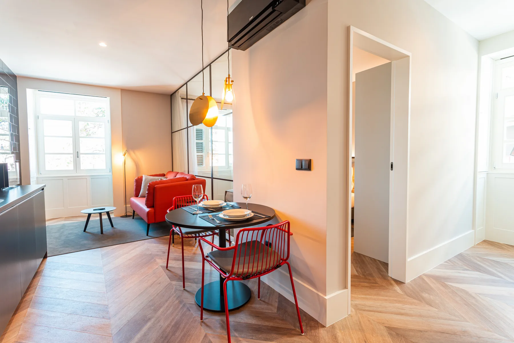 A bright living and dining area with red seating and a dining table.