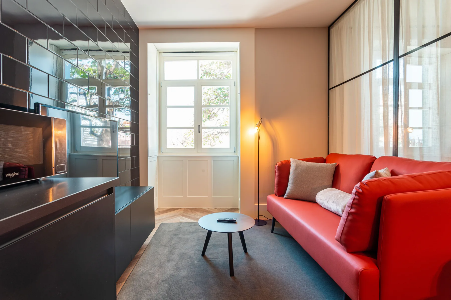 A living room with red seating, a low table, and a television.