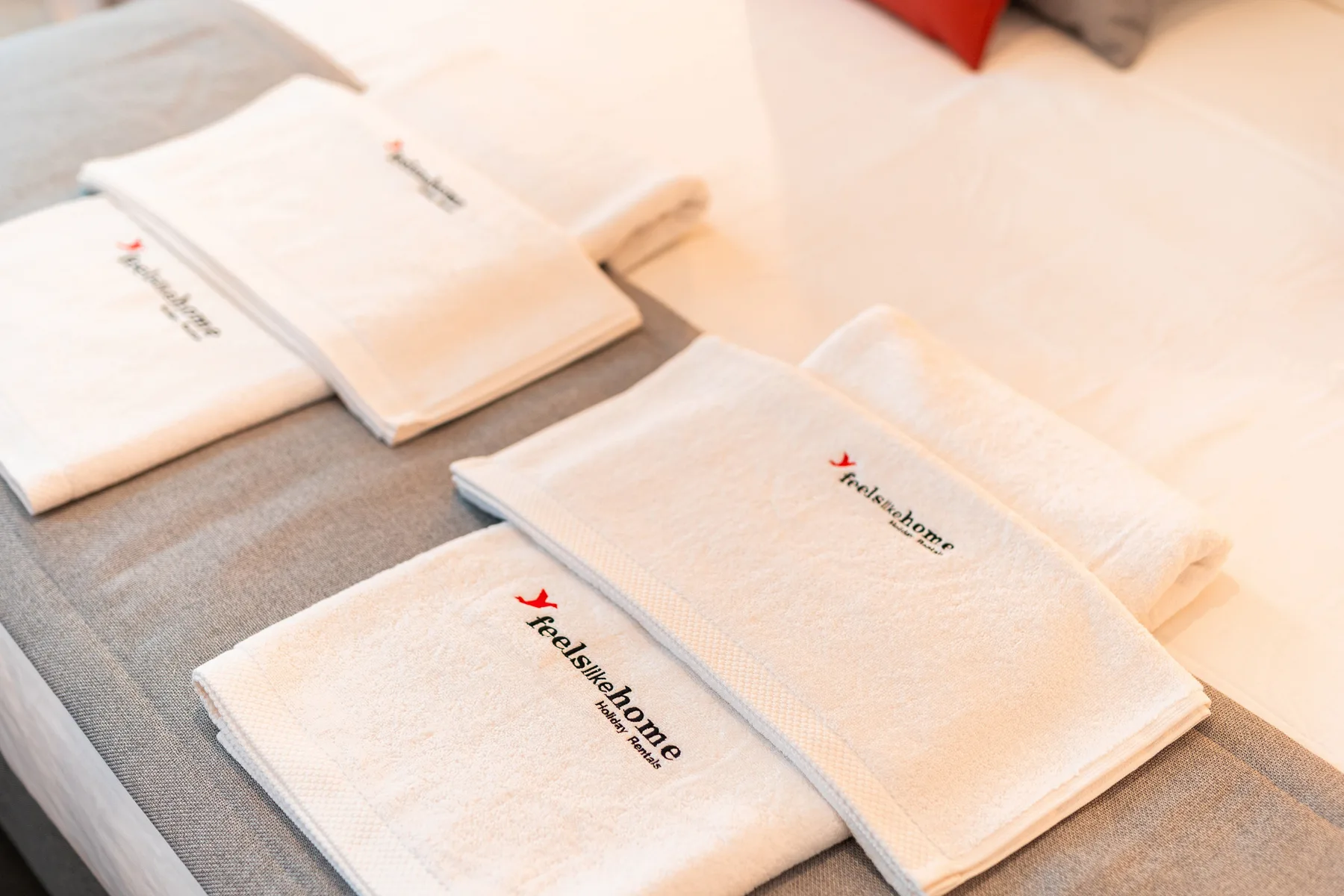 Folded white towels are arranged on a bed.