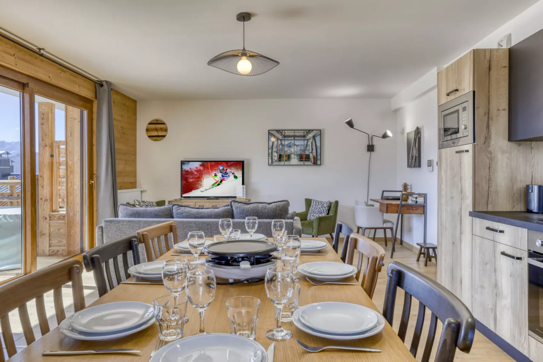 A dining area with a set table, seating, and a living area beyond.