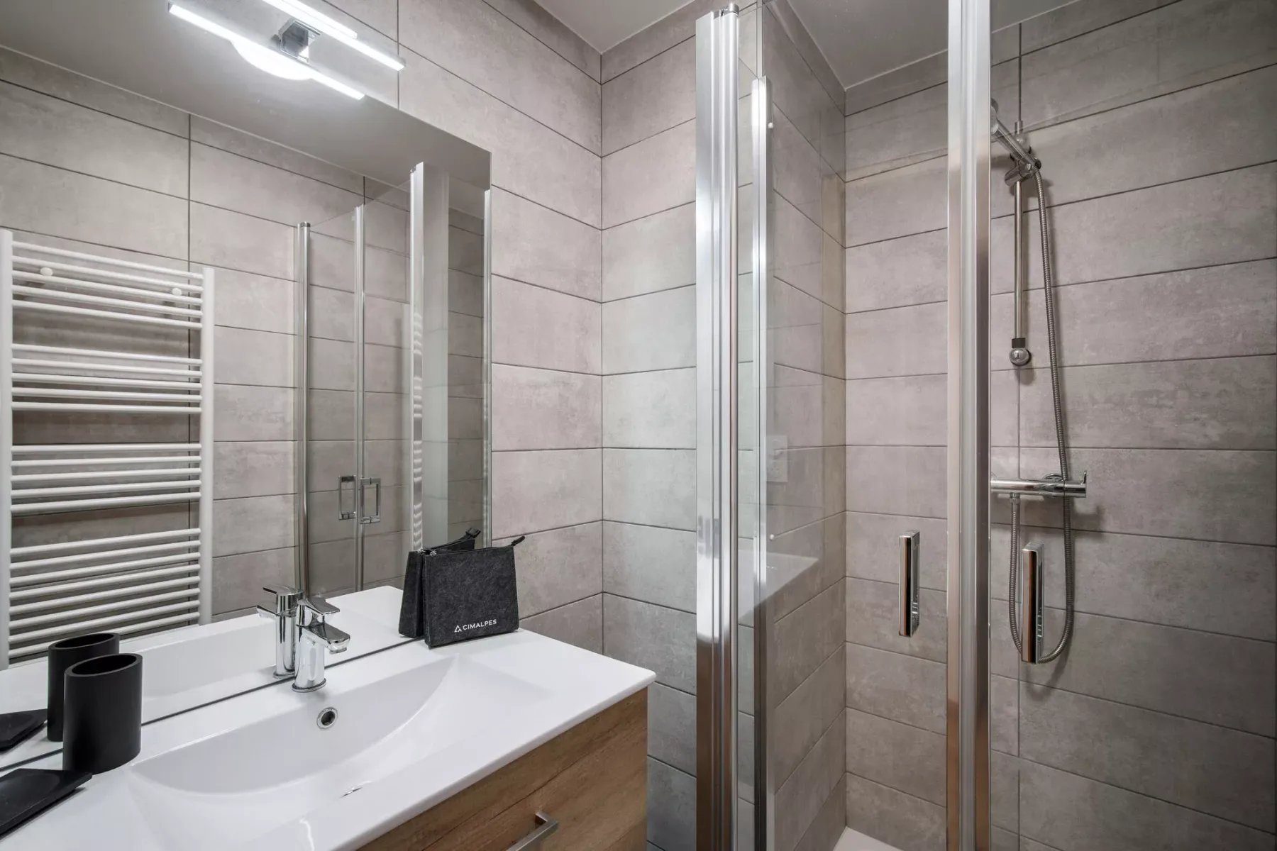 Un baño con azulejos, lavabo, espejo y ducha.