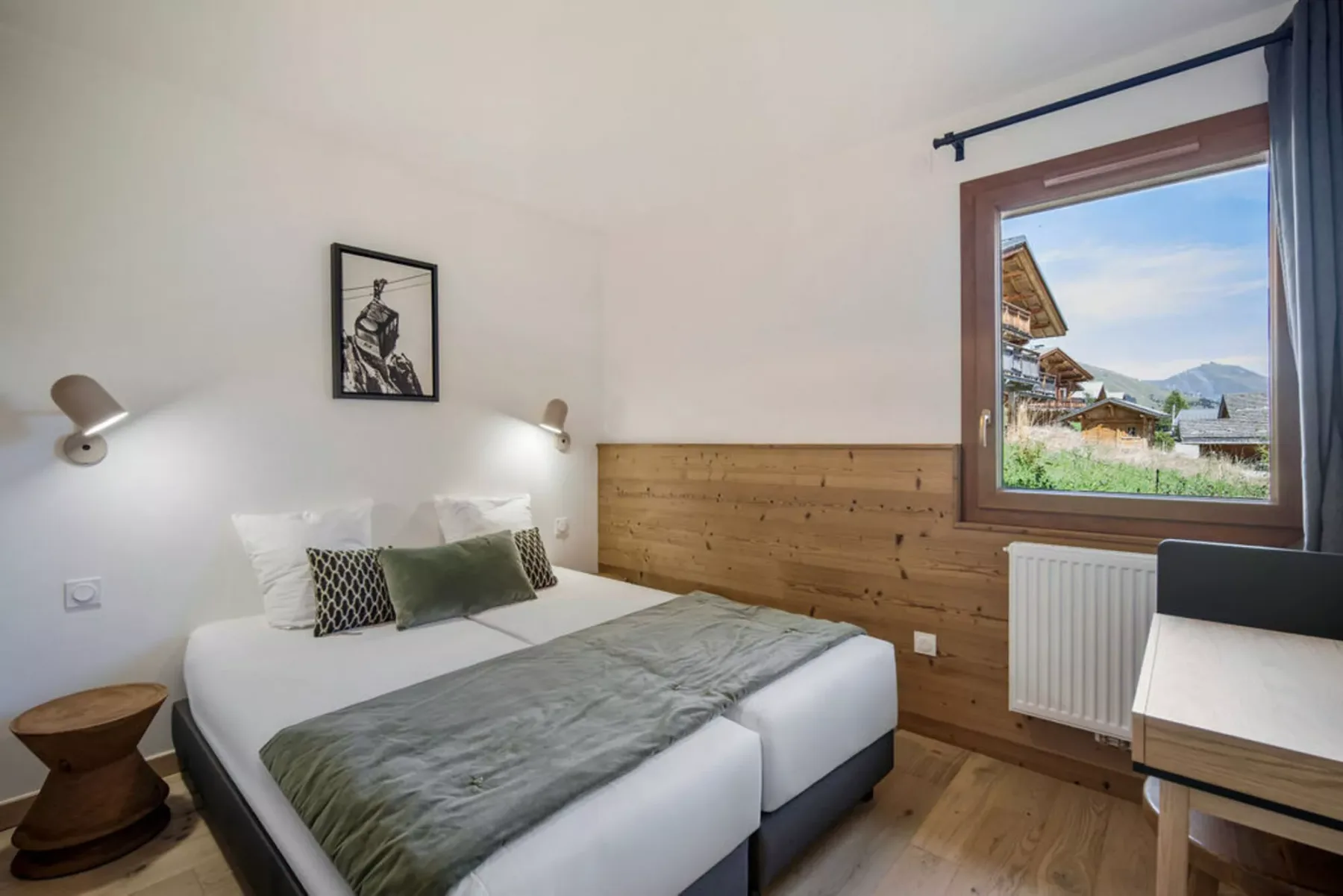 Un dormitorio con cama, pared revestida de madera y ventana con vistas a un paisaje montañoso.