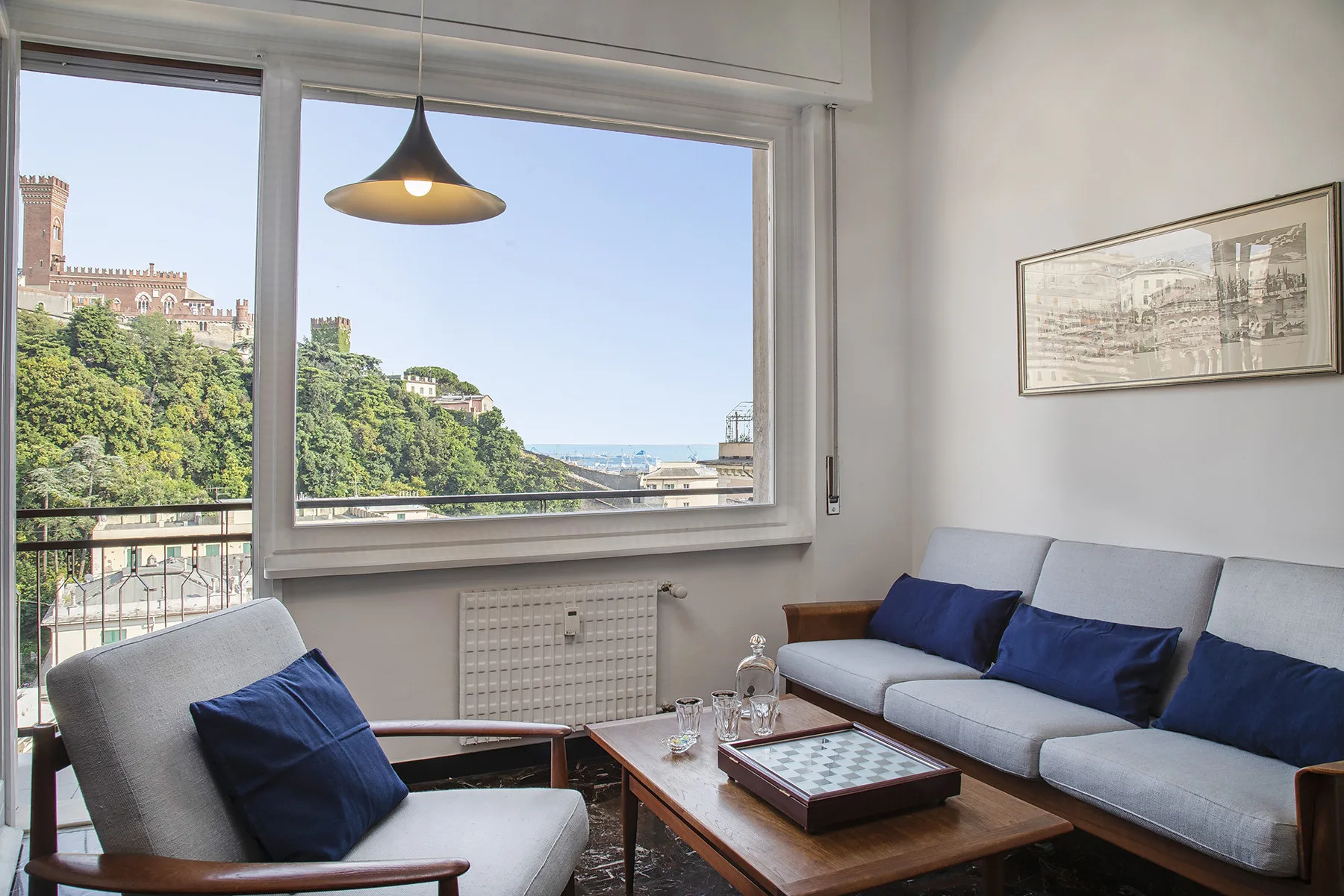 Una sala de estar con asientos alrededor de una mesa de centro de madera junto a una ventana grande.