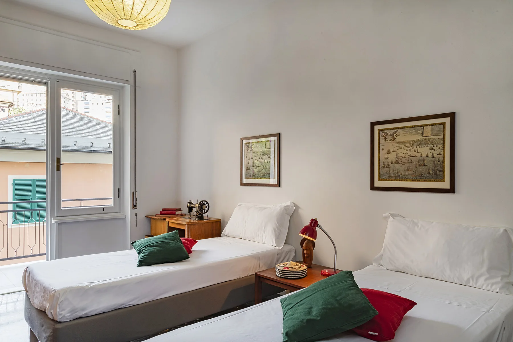 Un dormitorio luminoso con dos camas y cuadros en las paredes.