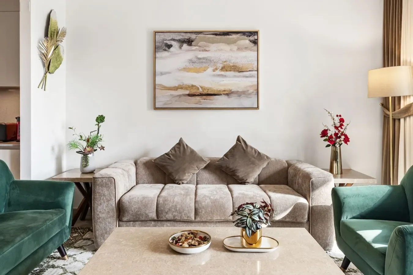 Una sala de estar con un sofá, dos sillones y una mesa de centro.