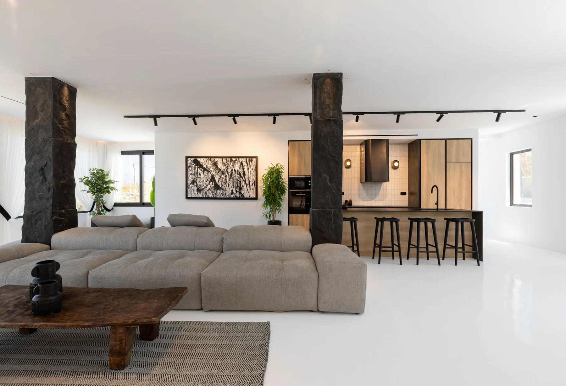 Un salón de planta abierta con asientos junto a una isla de cocina.