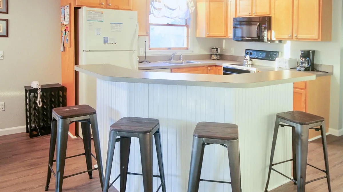 Una cocina con una barra curva y gabinetes de madera.