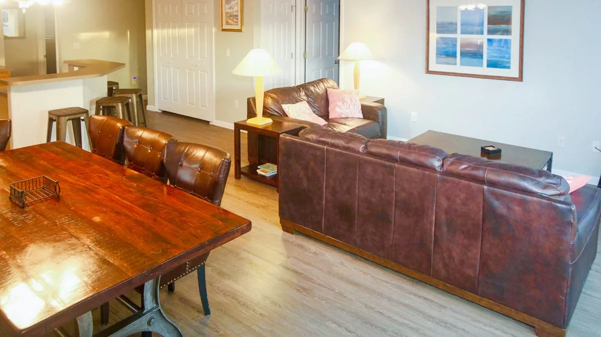 Una sala de estar con asientos de cuero, una mesa de centro y una mesa de comedor.