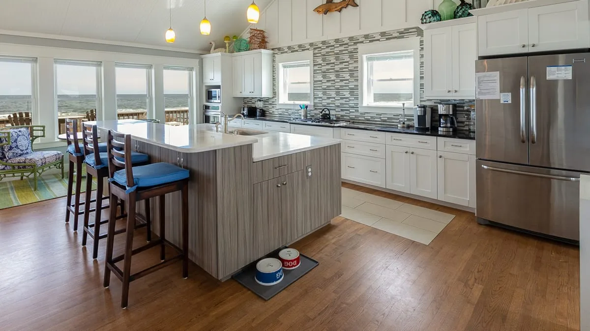 A bright kitchen with a central island and dining seating by the windows.