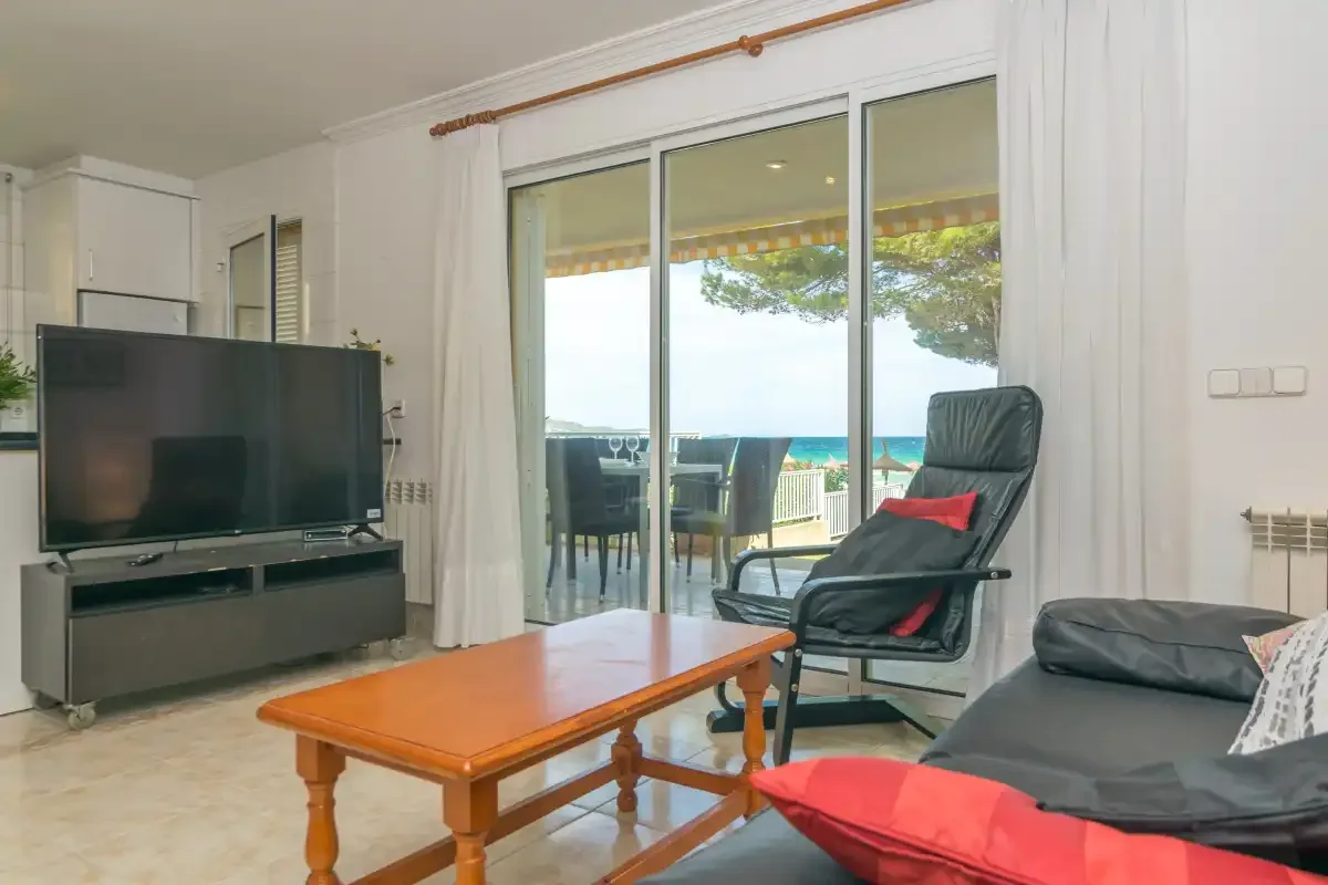 Sala de estar con asientos y una puerta corrediza de vidrio que da a un balcón.