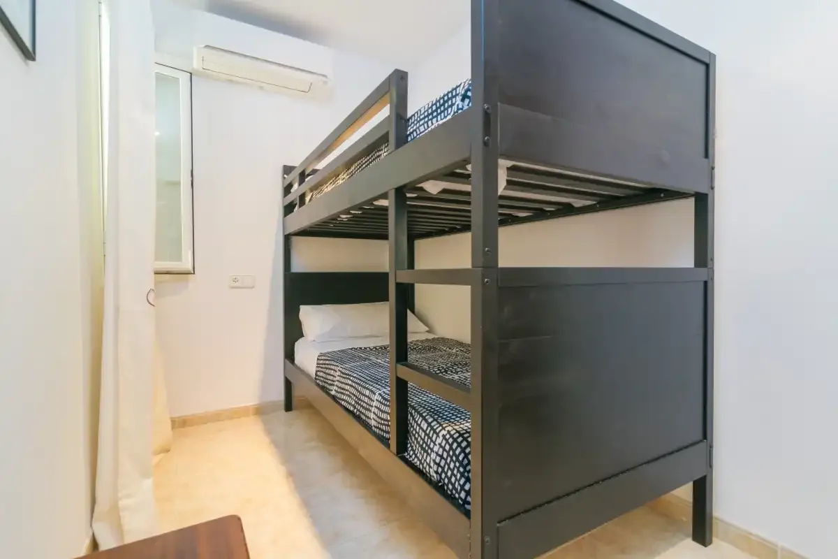 Una litera con ropa de cama estampada en un dormitorio luminoso.