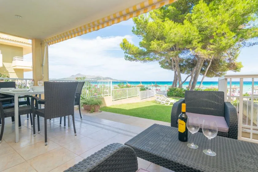 Una zona cubierta para comer al aire libre se abre a un jardín con vistas al mar.