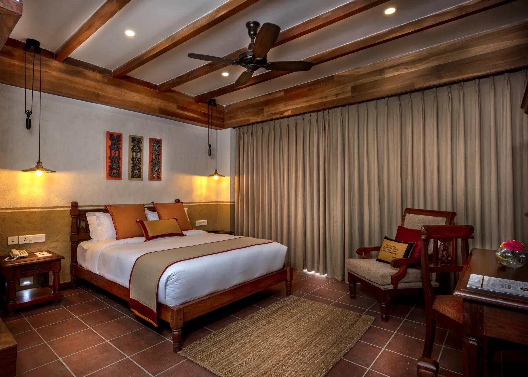 Heritage Deluxe Room with a hand-carved wooden bed and timber-beamed ceiling.