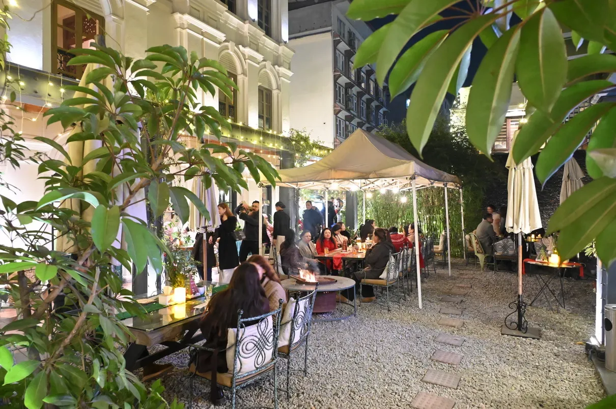 Daytime garden dining beneath parasols in the courtyard.