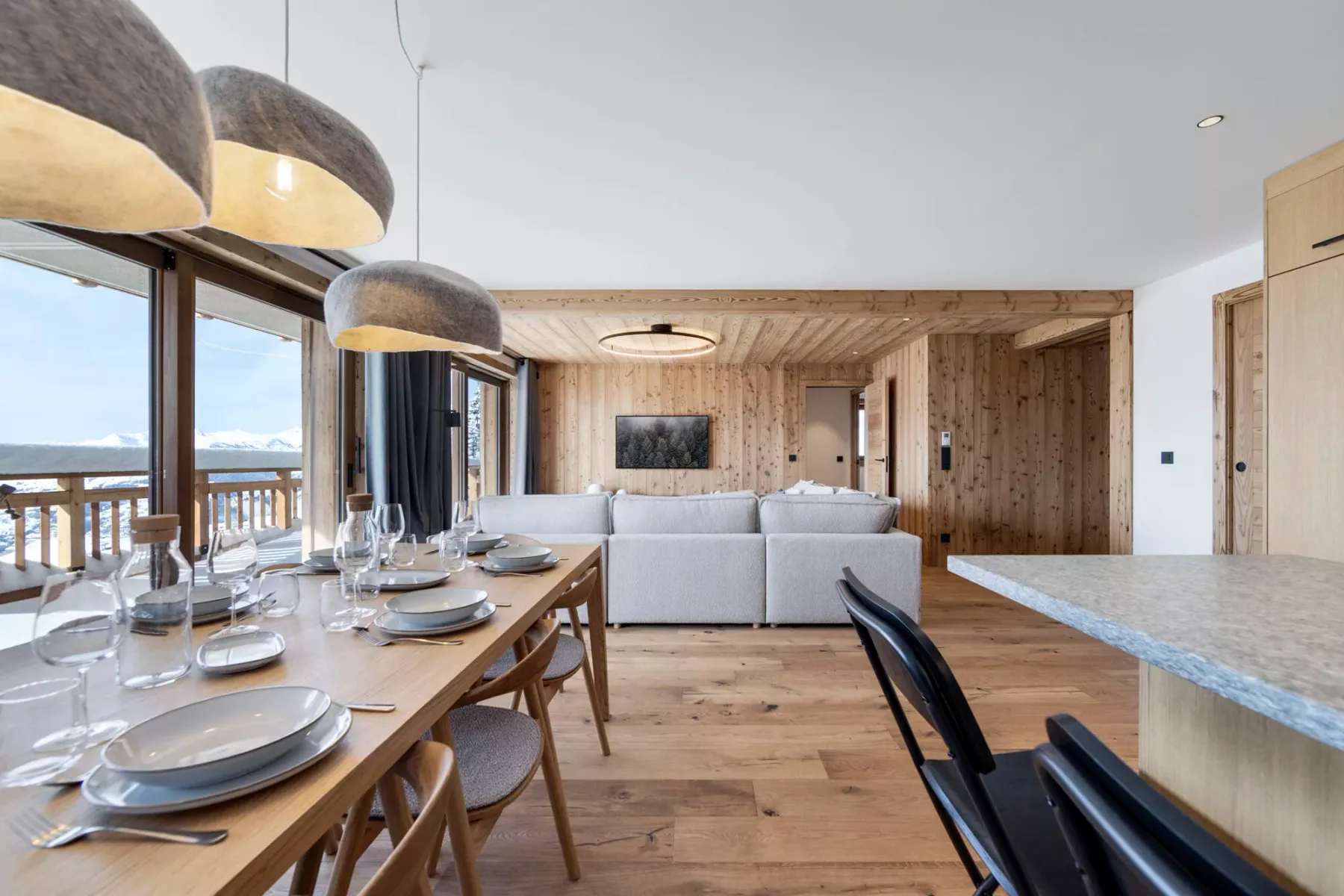 An open-plan dining and living area with a long dining table and seating.