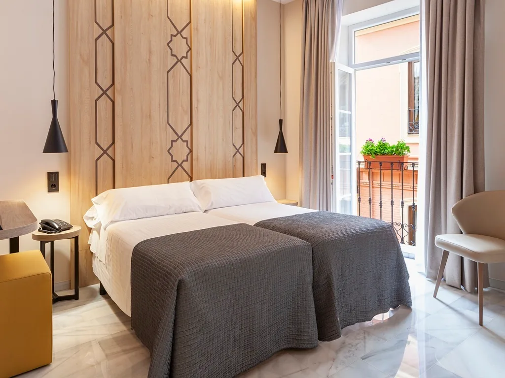 Habitación superior con dos camas individuales y balcón