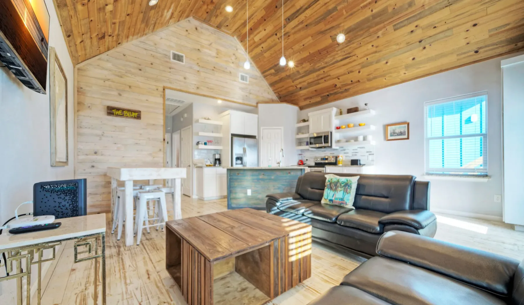 Una sala de estar de planta abierta con asientos, una mesa de comedor y una cocina.