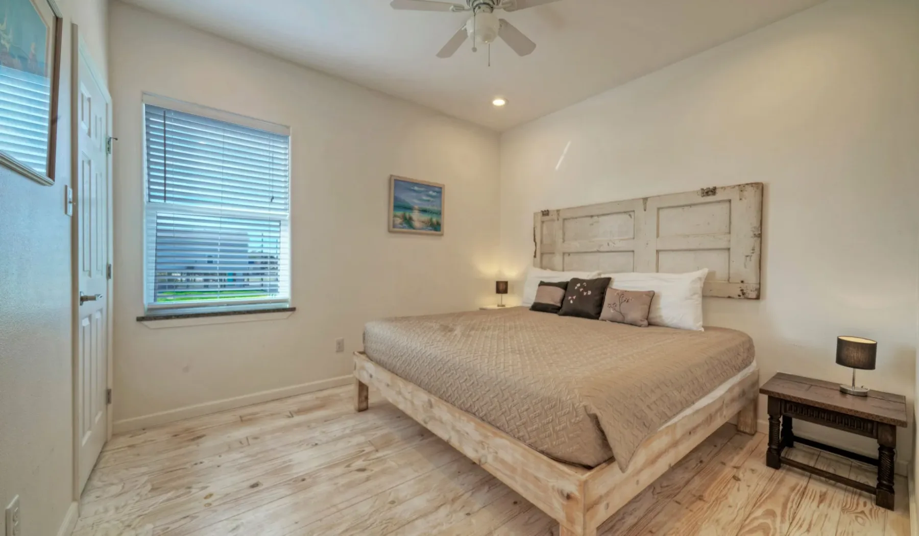 Un dormitorio con una cama grande bajo un panel decorativo.