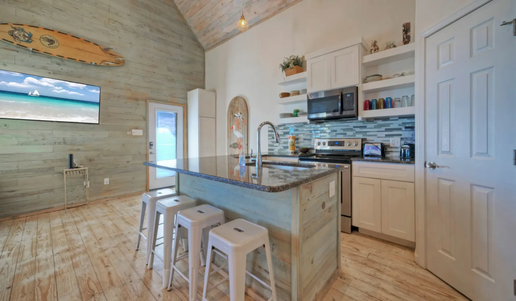 Una cocina luminosa con una isla central y muebles de madera clara.