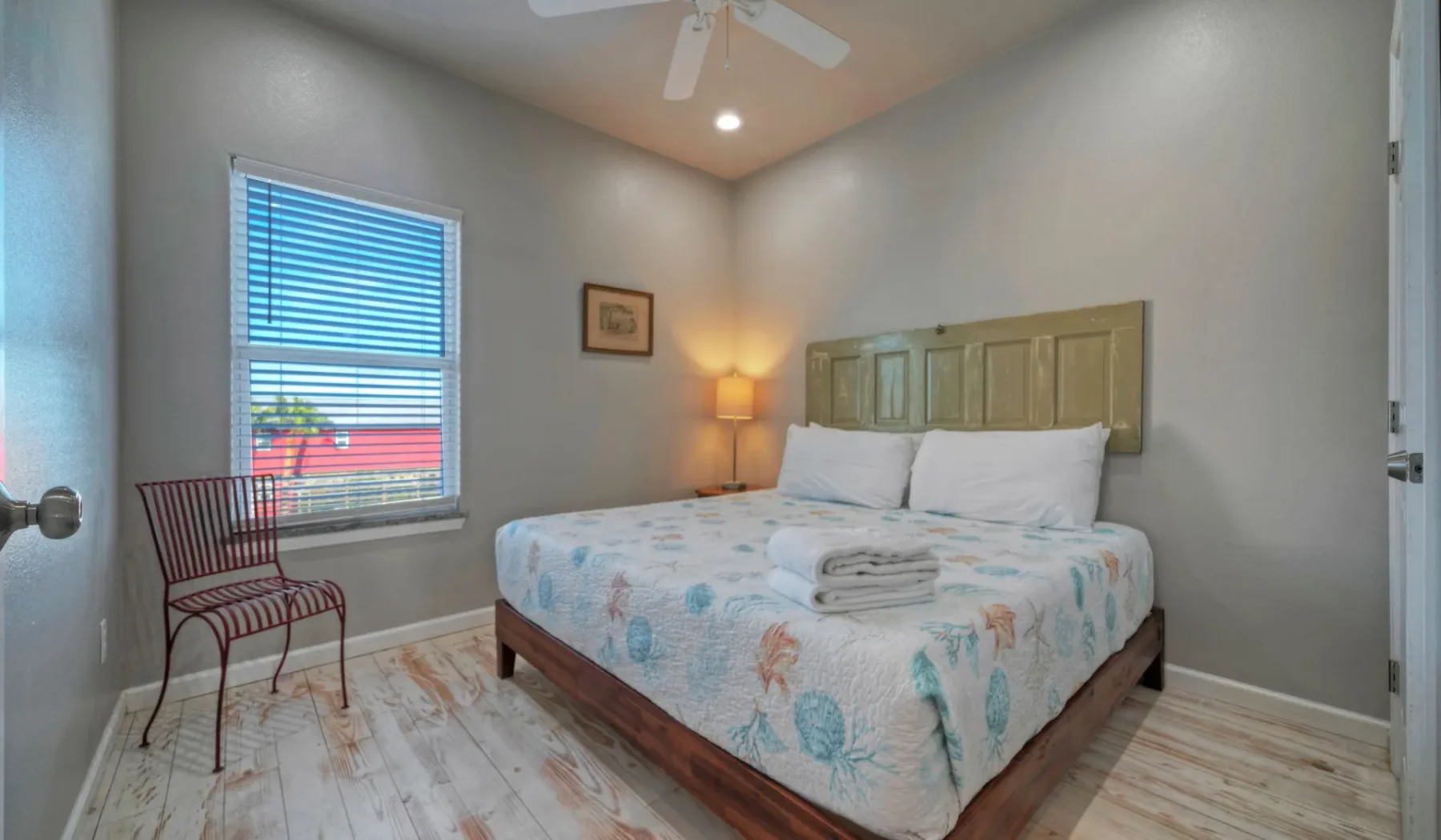 Un dormitorio con una cama, una ventana y una silla.
