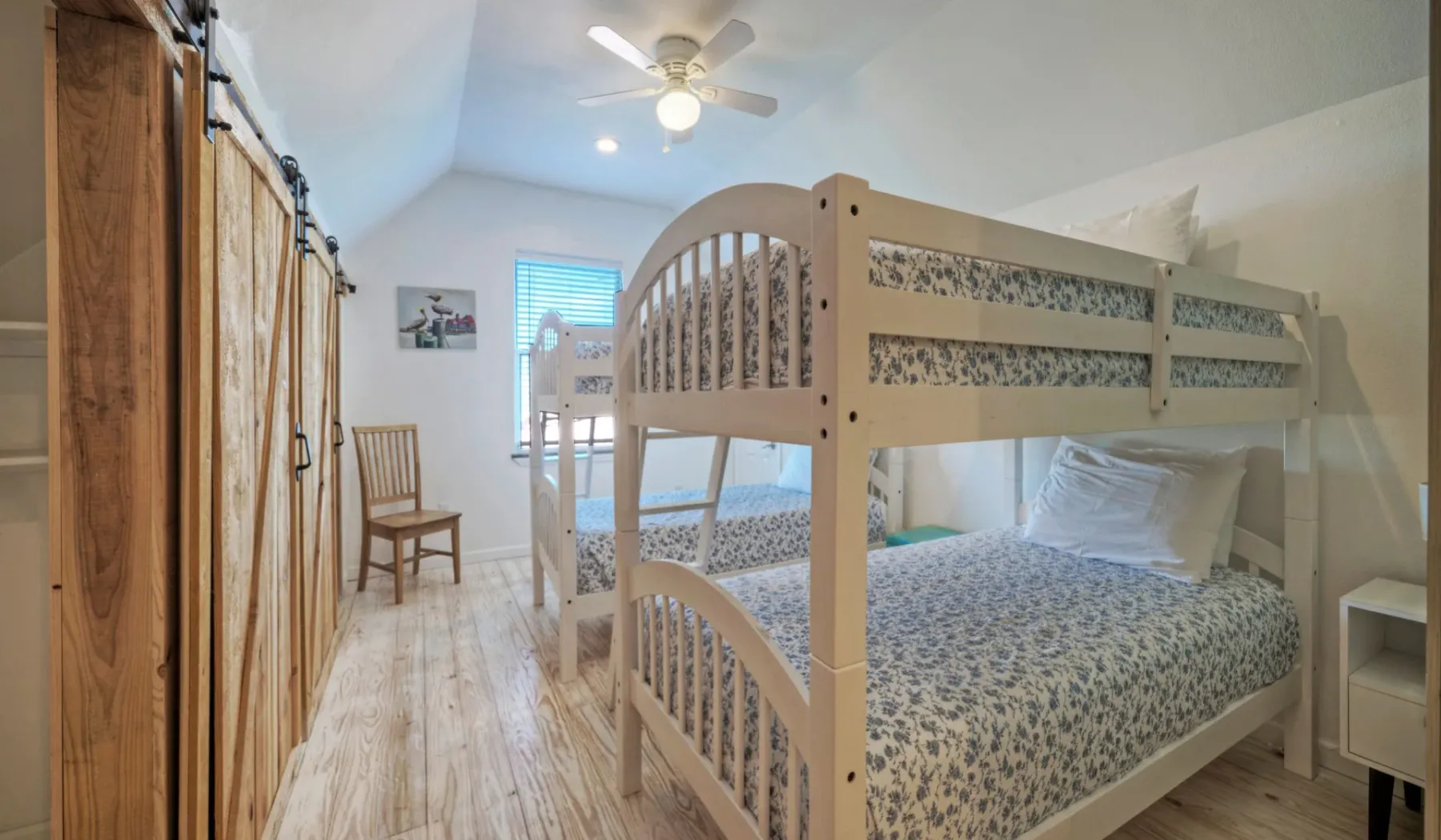 Un dormitorio con una litera de madera y ropa de cama estampada.