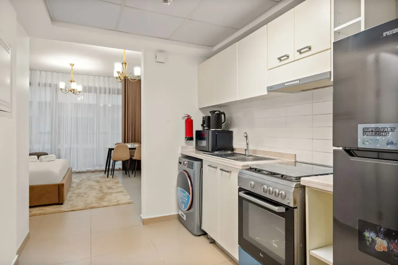 Una cocina compacta se abre a un comedor con una mesa y sillas.