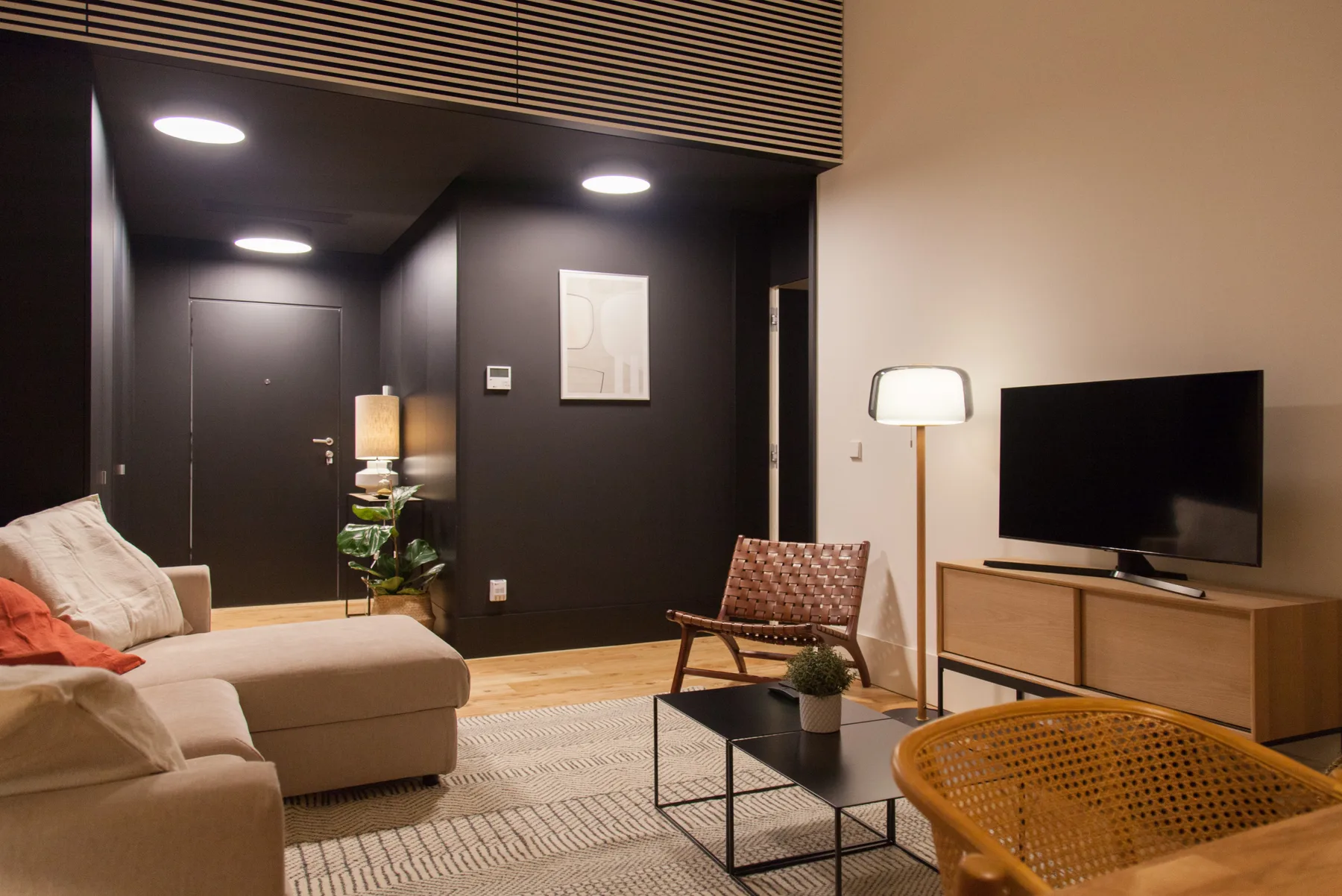 Una sala de estar con asientos, una mesa de centro y un televisor.