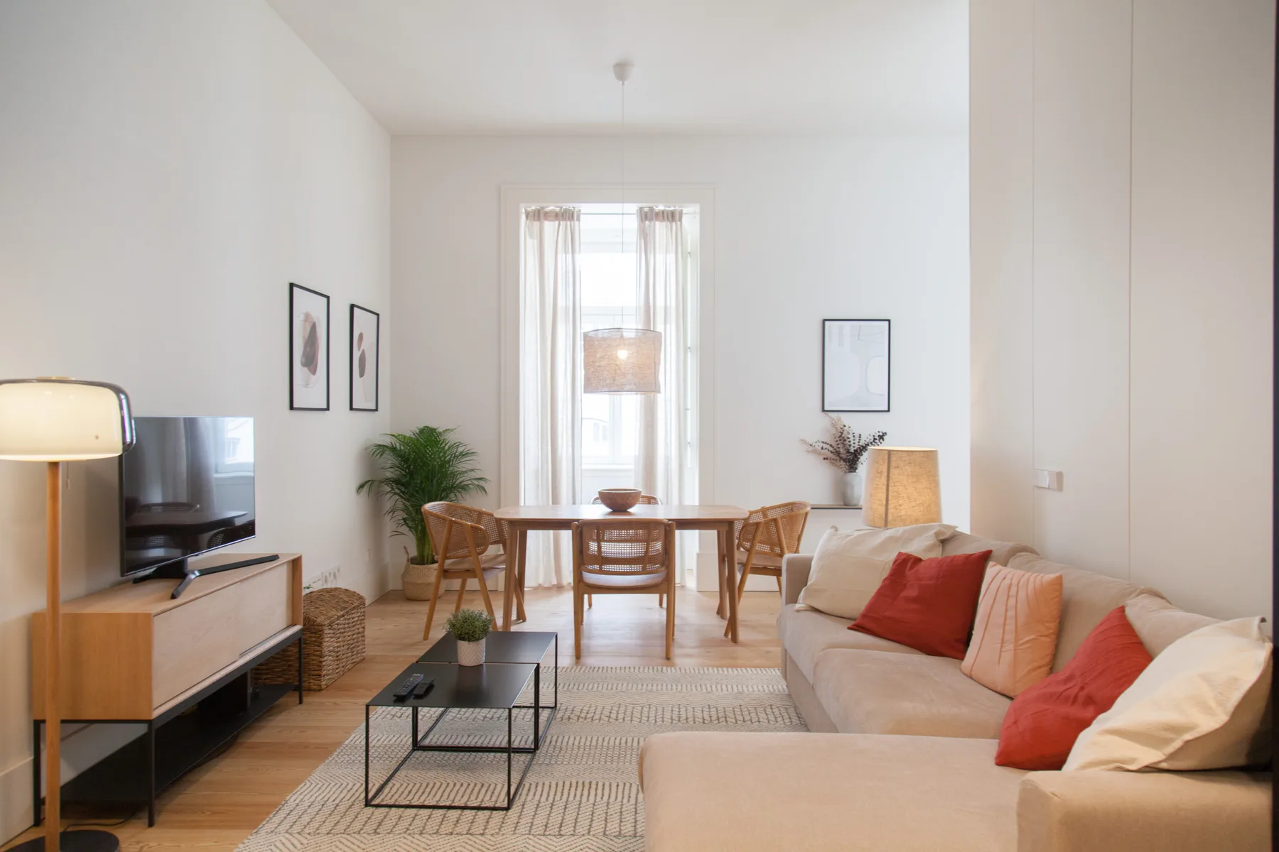 Una luminosa sala de estar y comedor con una mesa junto a la ventana y asientos.