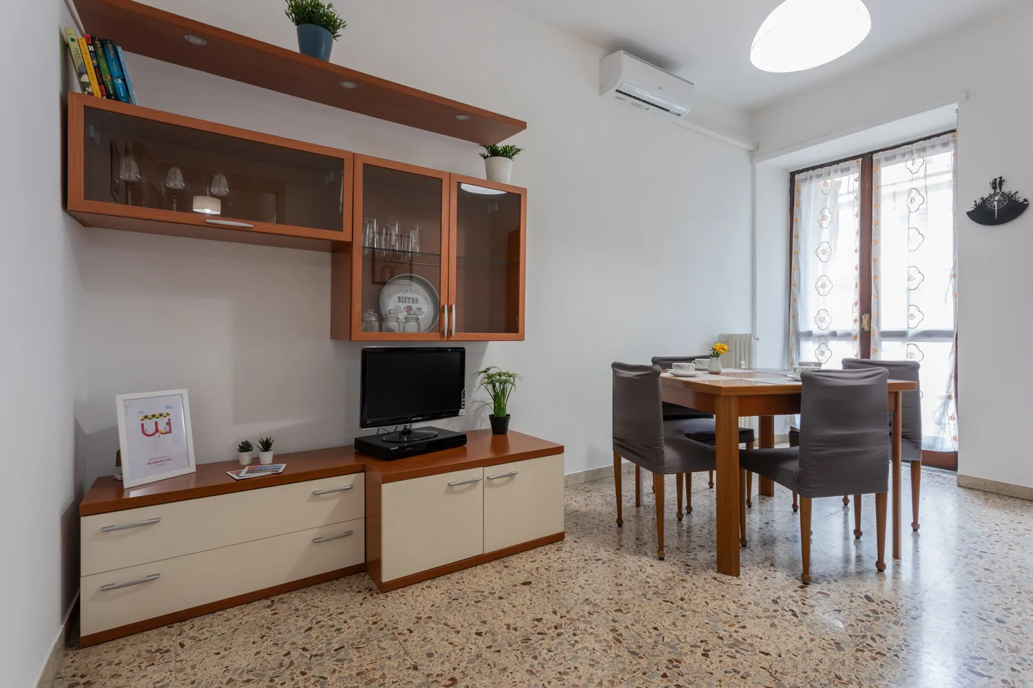 Comedor con una mesa de madera y sillas junto a un mueble de pared.