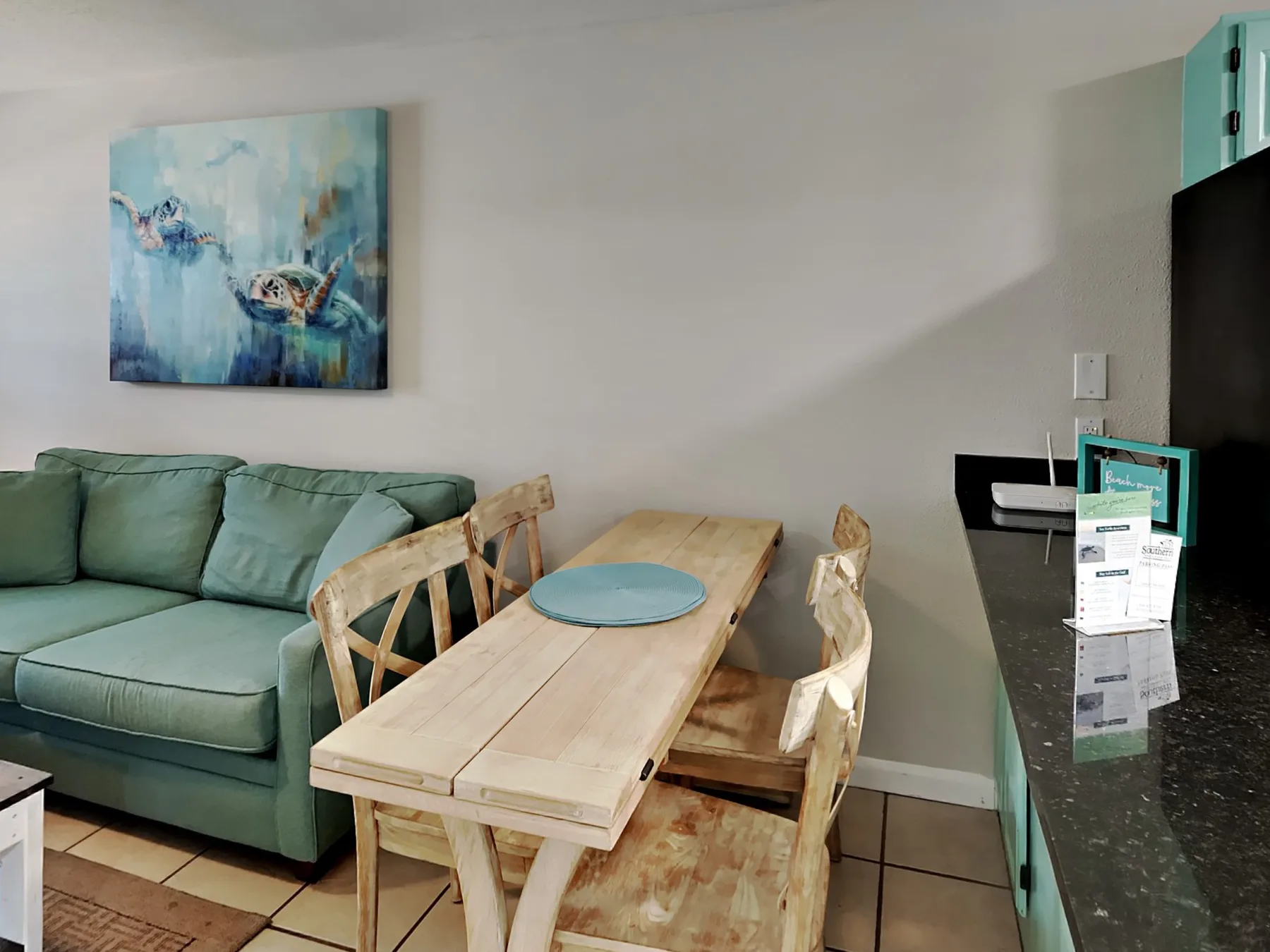 Una sala de estar y comedor con un sofá verde y una mesa de madera.