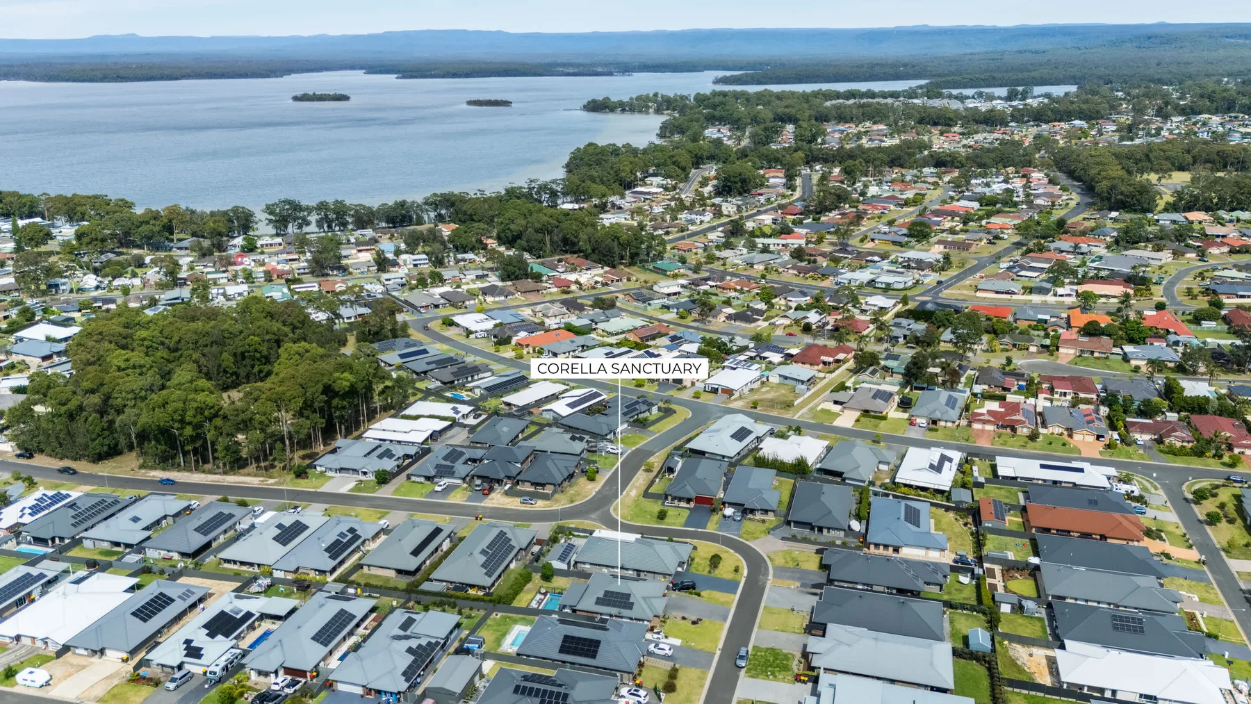 Vista aérea de un barrio residencial junto a un gran lago.