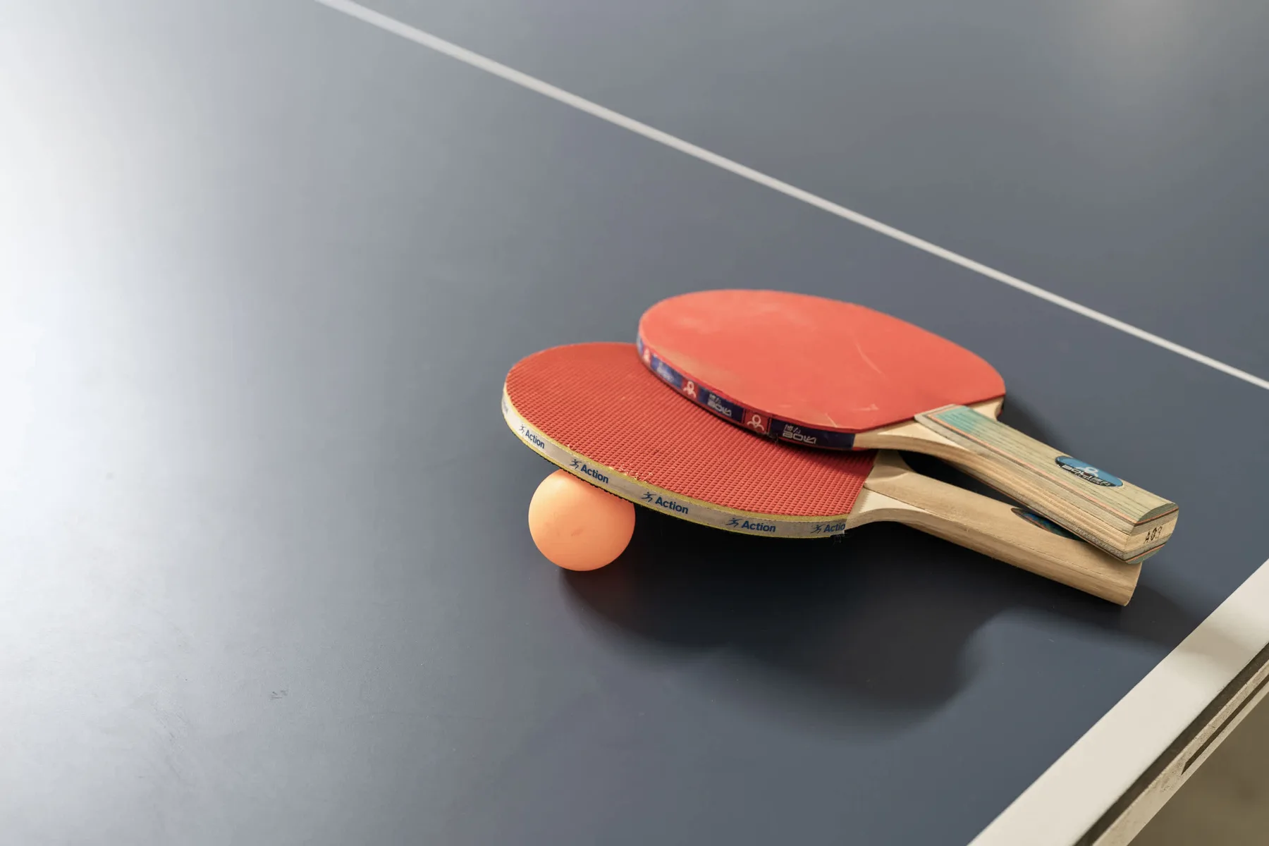 Una mesa de ping-pong con palas y una pelota.