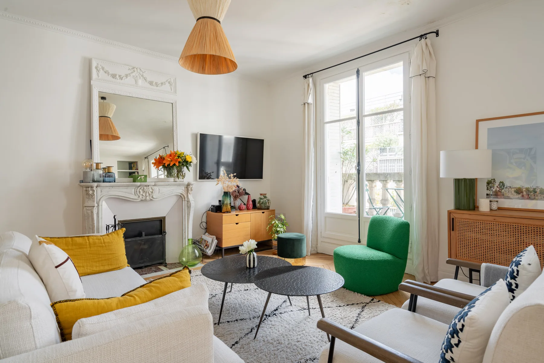 A bright living room with a fireplace, seating, and large windows.