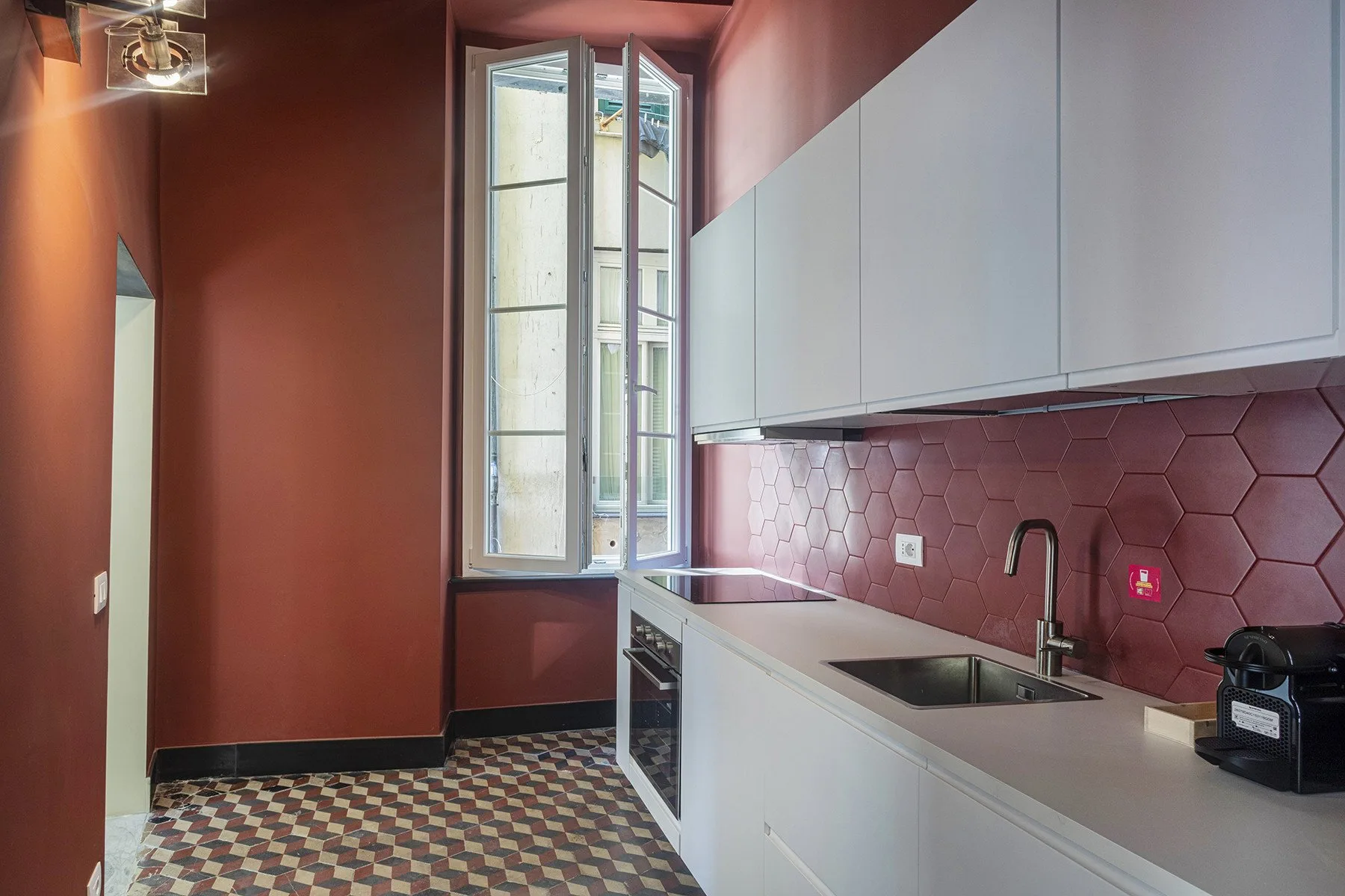 A modern kitchen with white cabinets and a tiled backsplash.