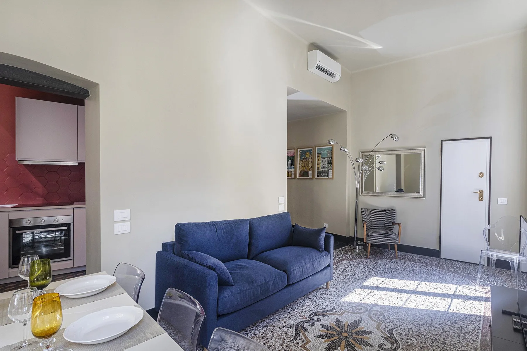 A living room with blue seating and a patterned rug.