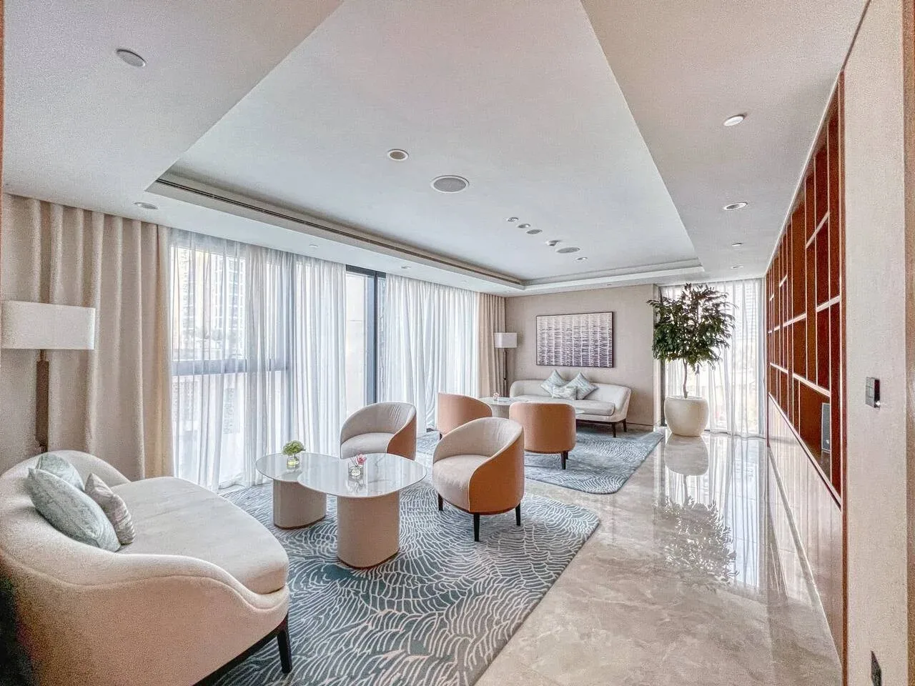 A bright living room with seating around a coffee table and large windows.