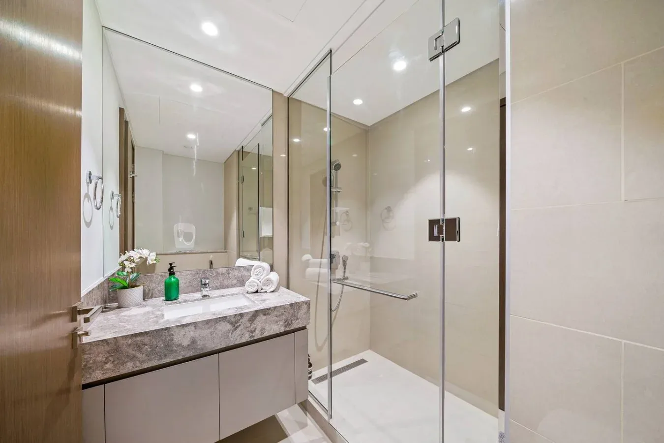 A bathroom with a vanity and a glass-enclosed shower.