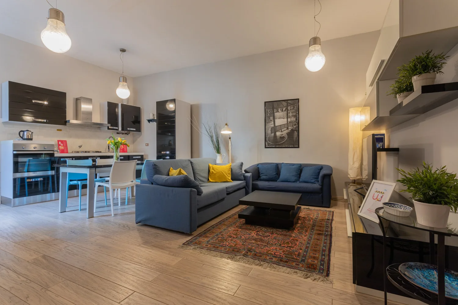 An open-plan living room and kitchen with seating arranged around a coffee table.