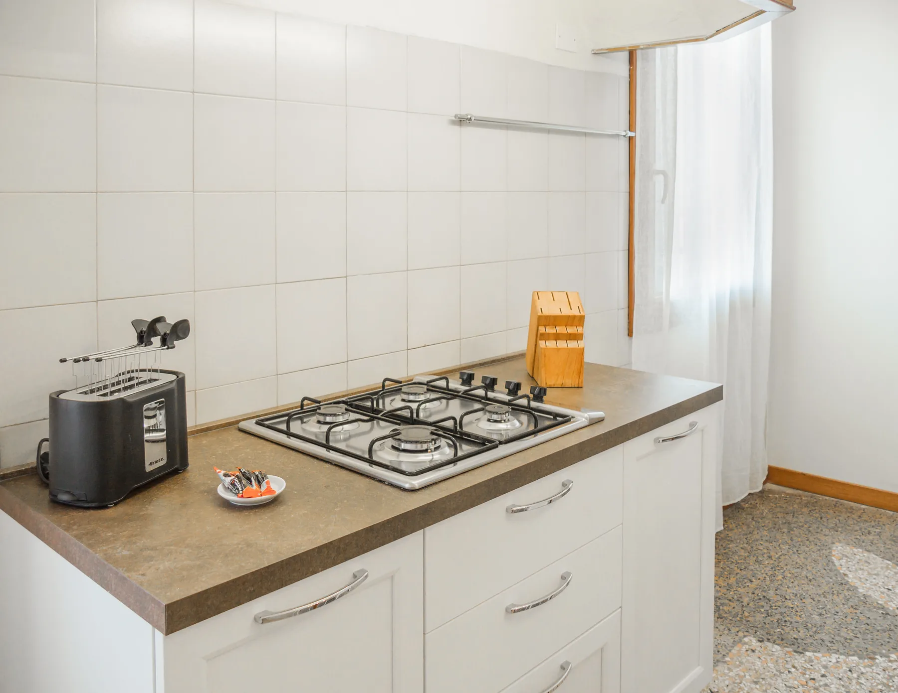 A compact kitchen with a countertop gas cooktop and toaster.