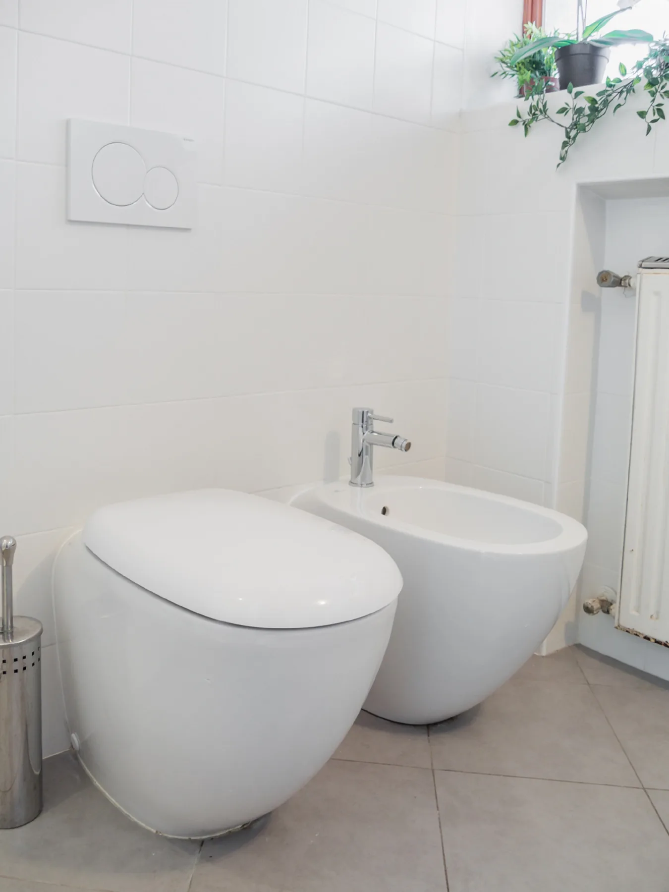 A tiled bathroom with a toilet and a bidet.
